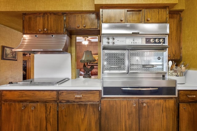 kitchen with stainless steel oven, extractor fan, electric stovetop, and light countertops