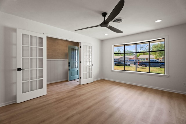 empty room with recessed lighting, wood finished floors, a ceiling fan, and french doors