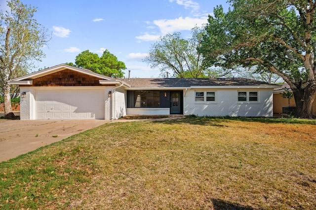 single story home with brick siding, an attached garage, a front lawn, and concrete driveway
