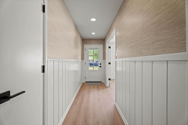 hallway with light wood-type flooring, wainscoting, and recessed lighting