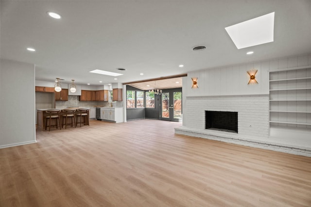 unfurnished living room featuring a skylight, visible vents, and recessed lighting