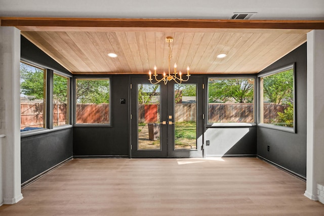 unfurnished sunroom featuring visible vents, a notable chandelier, and french doors