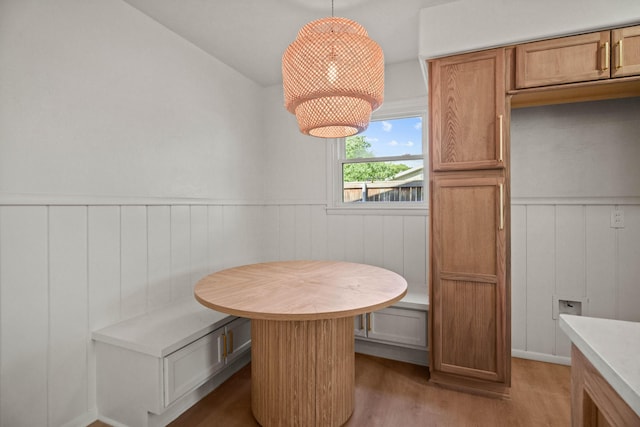 dining space featuring wainscoting, light wood-style flooring, and breakfast area