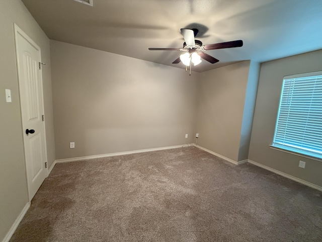 carpeted spare room featuring ceiling fan