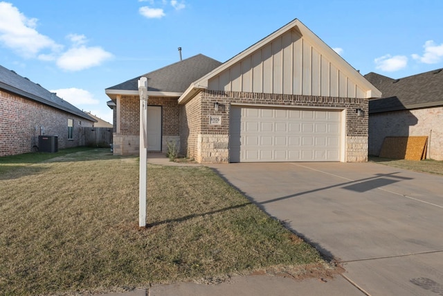 view of front of home with a garage, cooling unit, and a front lawn