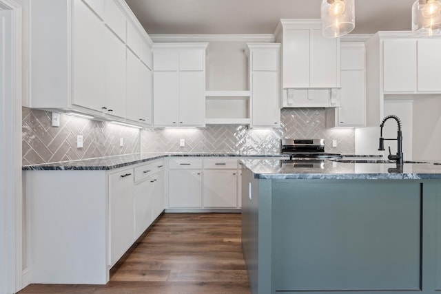 kitchen with sink, hanging light fixtures, dark stone countertops, stainless steel electric stove, and white cabinets