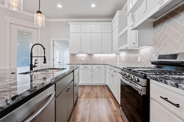 kitchen featuring stainless steel appliances, sink, hanging light fixtures, and white cabinets