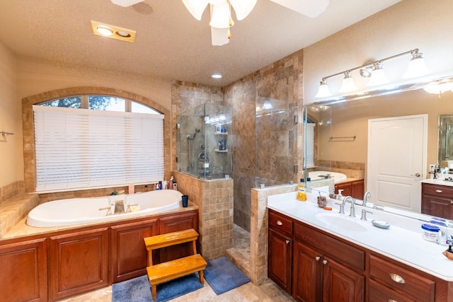 bathroom featuring a garden tub, vanity, a walk in shower, and a ceiling fan