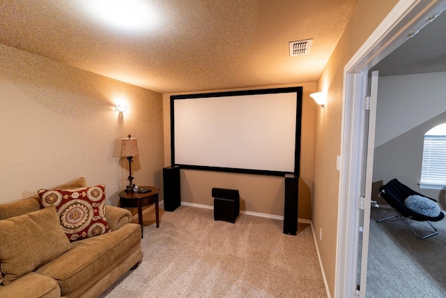 cinema room with baseboards, visible vents, carpet floors, and a textured ceiling