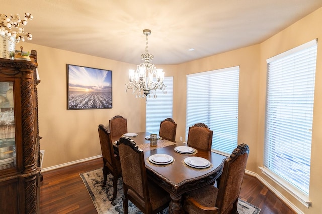 dining room featuring baseboards, an inviting chandelier, and dark wood-style flooring