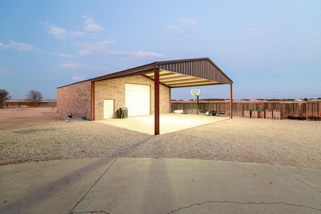 exterior space with an outdoor structure, driveway, and fence