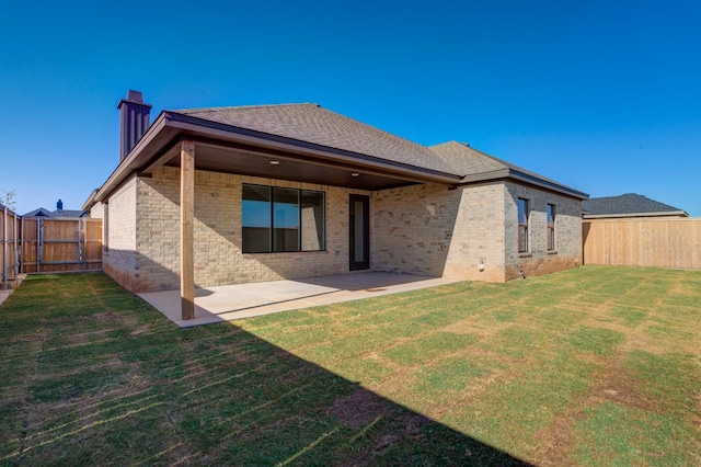 back of house featuring a patio area and a lawn