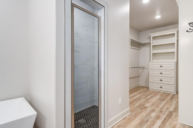 bathroom with hardwood / wood-style flooring and independent shower and bath