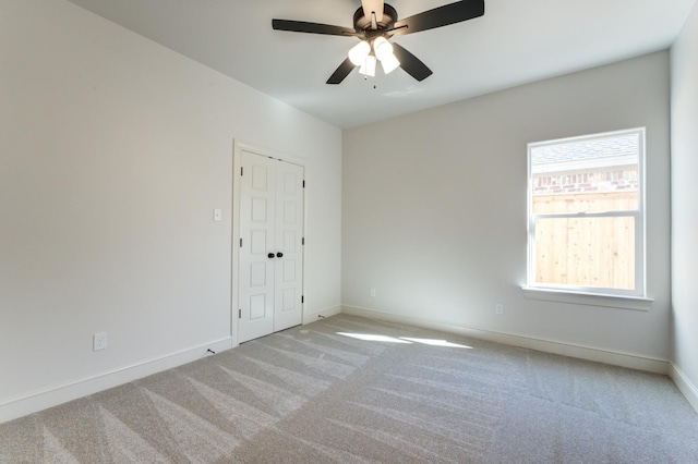 empty room featuring light colored carpet and ceiling fan