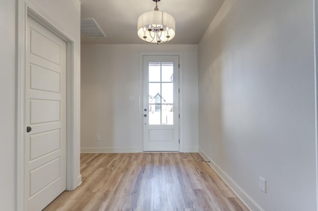 doorway featuring light hardwood / wood-style flooring and a notable chandelier