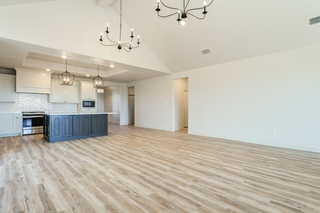 kitchen featuring a kitchen island, pendant lighting, white cabinetry, a notable chandelier, and stainless steel electric range