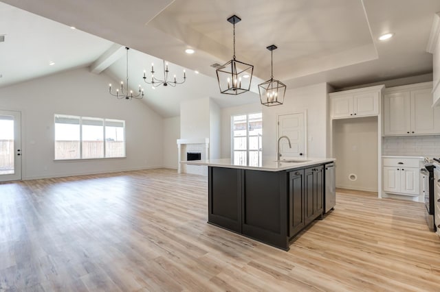 kitchen with pendant lighting, stainless steel appliances, sink, and a center island with sink