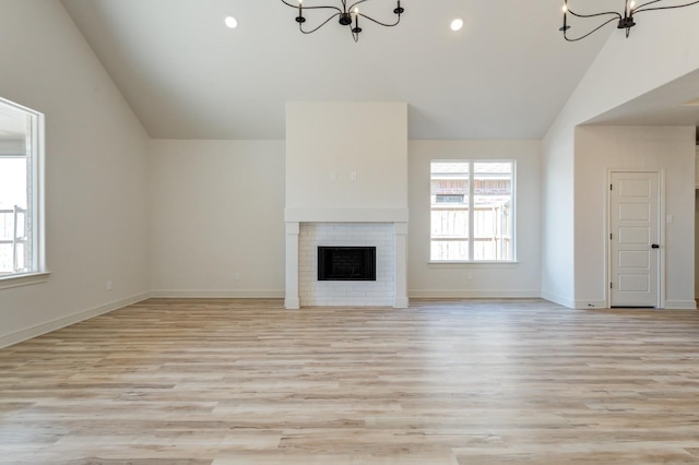 unfurnished living room with a notable chandelier, a fireplace, and plenty of natural light