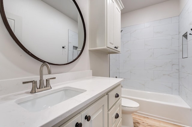 full bathroom with vanity, wood-type flooring, toilet, and tiled shower / bath