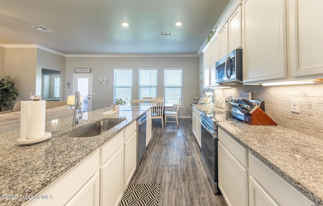3301 Venita Ave, Lubbock, TX 79407 - kitchen featuring stainless steel appliances, ornamental molding, dark wood finished floors, light stone countertops, and backsplash
