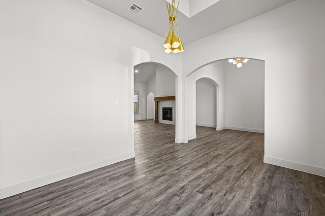 unfurnished living room with dark hardwood / wood-style floors and a tile fireplace