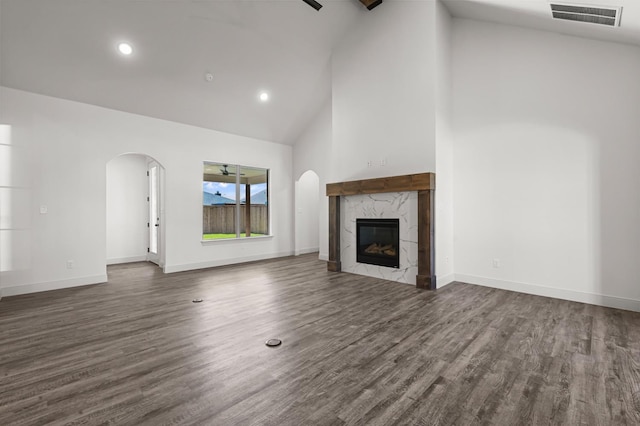 unfurnished living room featuring dark hardwood / wood-style floors, a fireplace, and high vaulted ceiling