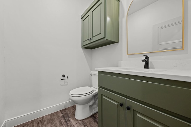 bathroom featuring wood-type flooring, vanity, and toilet