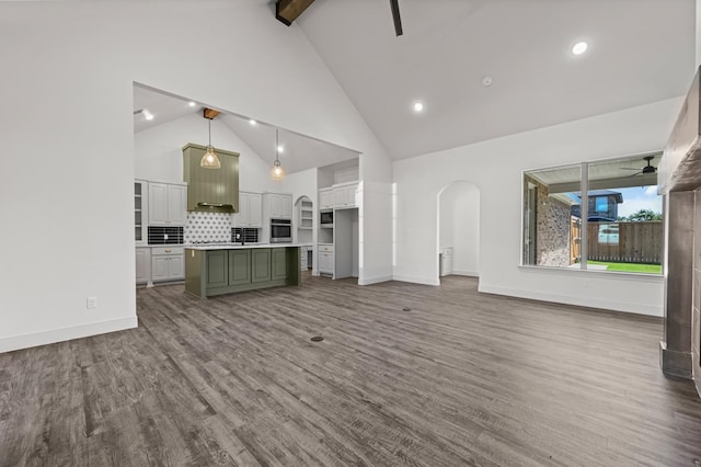 unfurnished living room featuring beam ceiling, high vaulted ceiling, hardwood / wood-style floors, and ceiling fan