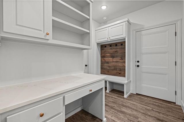 unfurnished office featuring dark hardwood / wood-style flooring and built in desk