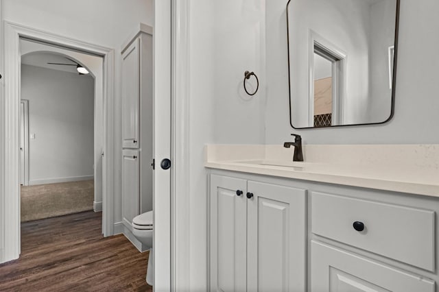 bathroom with hardwood / wood-style flooring, vanity, and toilet