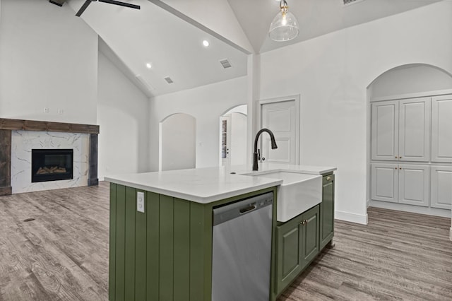 kitchen featuring stainless steel dishwasher, light hardwood / wood-style floors, sink, and a center island with sink