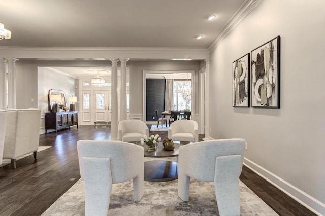 dining area featuring ornamental molding, dark hardwood / wood-style flooring, decorative columns, and a notable chandelier