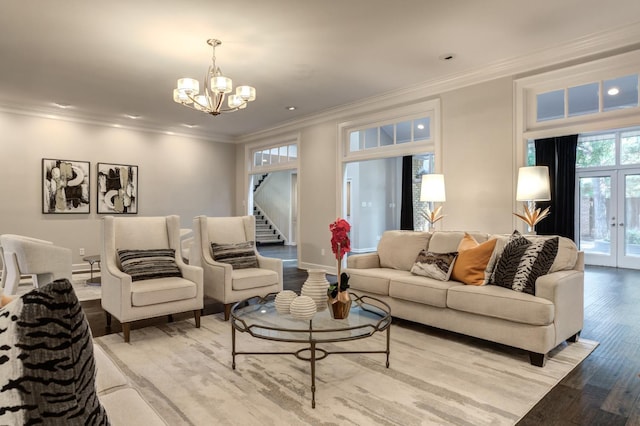 living room with french doors, crown molding, a chandelier, and light wood-type flooring