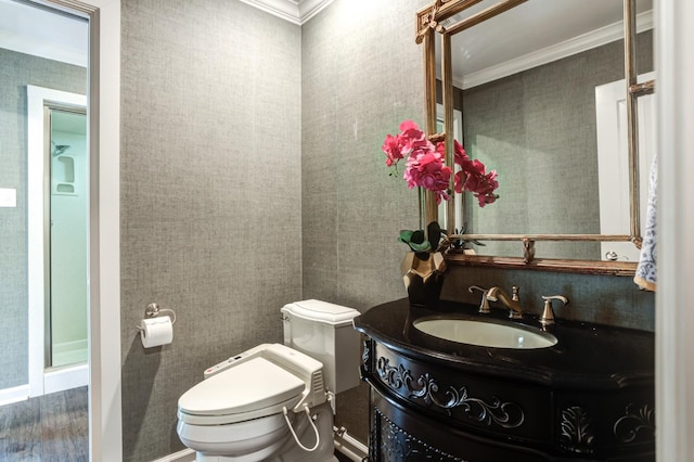 bathroom featuring vanity, hardwood / wood-style floors, ornamental molding, and toilet