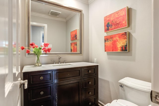 bathroom with ornamental molding, toilet, and vanity