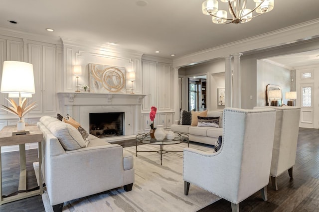 living room featuring ornate columns, light wood-type flooring, ornamental molding, a notable chandelier, and a premium fireplace