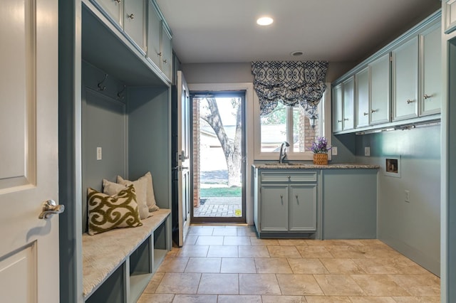 interior space featuring cabinets, sink, washer hookup, and light tile patterned floors