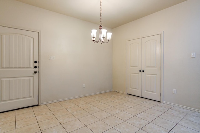 tiled empty room with a chandelier