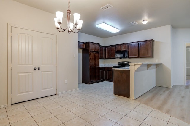 kitchen with black appliances, dark brown cabinets, pendant lighting, a chandelier, and light hardwood / wood-style flooring