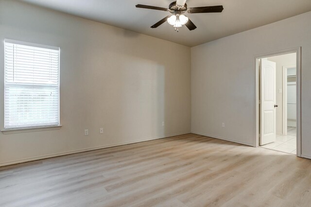 empty room with ceiling fan and light hardwood / wood-style flooring