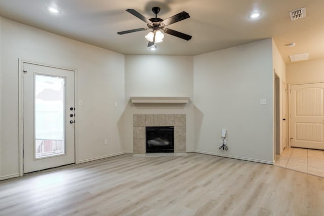 unfurnished living room with light hardwood / wood-style flooring, ceiling fan, and a tile fireplace