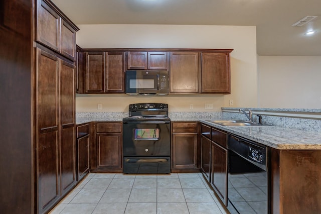 kitchen featuring light stone counters, dark brown cabinetry, black appliances, sink, and light tile patterned floors