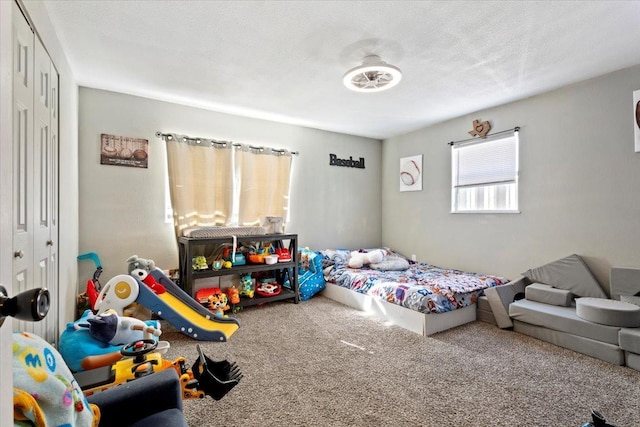 bedroom with carpet floors, a closet, and a textured ceiling