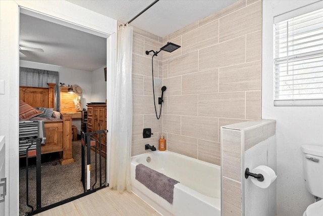 bathroom with shower / bathtub combination with curtain and toilet