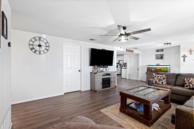 living room with dark hardwood / wood-style flooring and ceiling fan