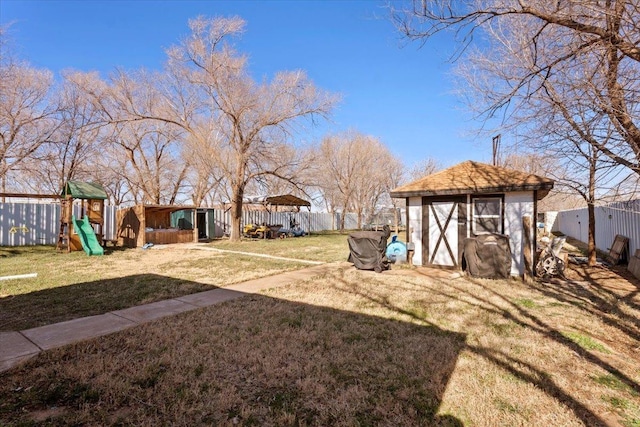 view of yard with a storage shed and a playground