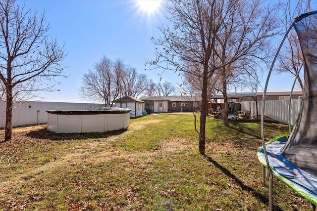 view of yard featuring a covered pool and a trampoline