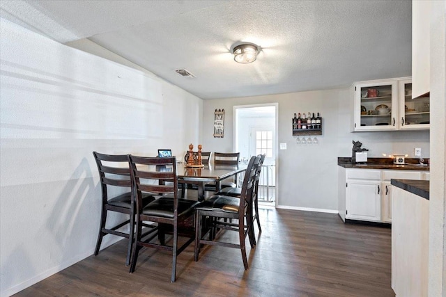 dining space featuring dark hardwood / wood-style floors and a textured ceiling