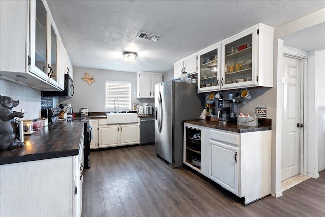 kitchen featuring white cabinetry, appliances with stainless steel finishes, sink, and dark hardwood / wood-style flooring