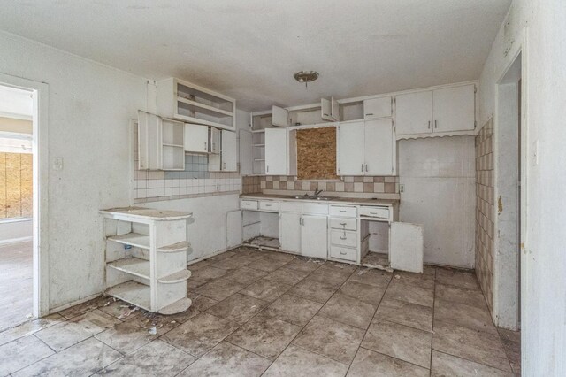 kitchen featuring white cabinetry, sink, and tasteful backsplash